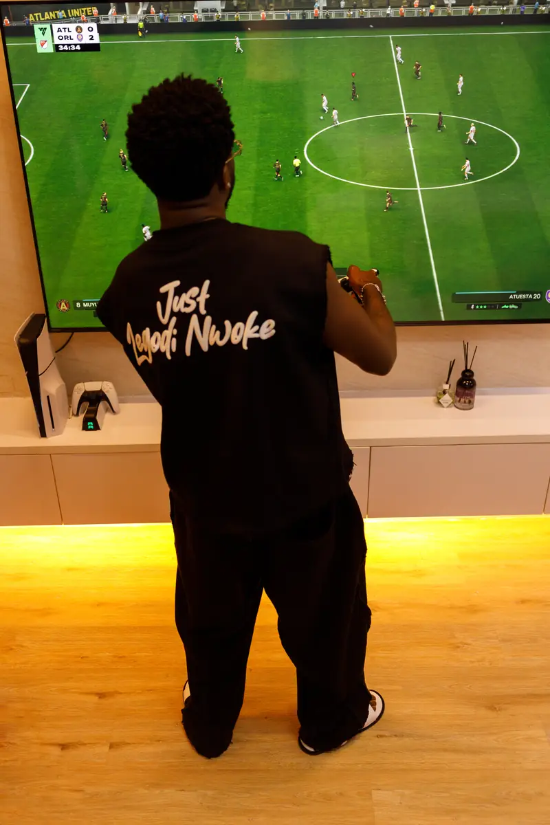 A man in the Black set watching football, the back print showing