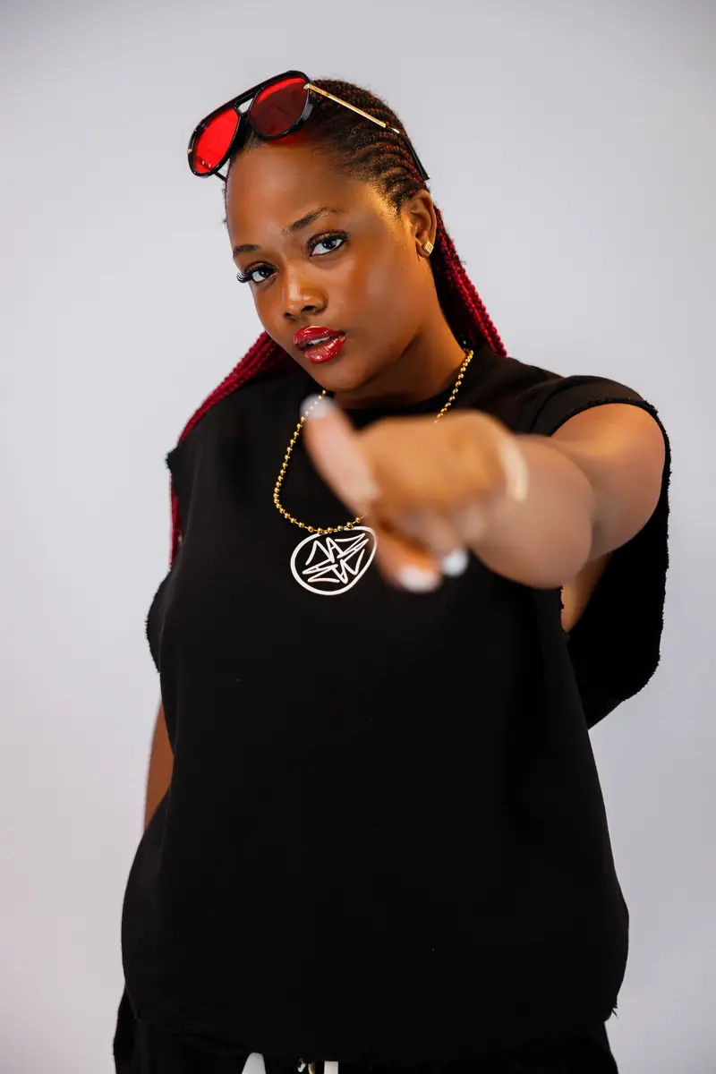 A woman in the Black set pointing at the camera